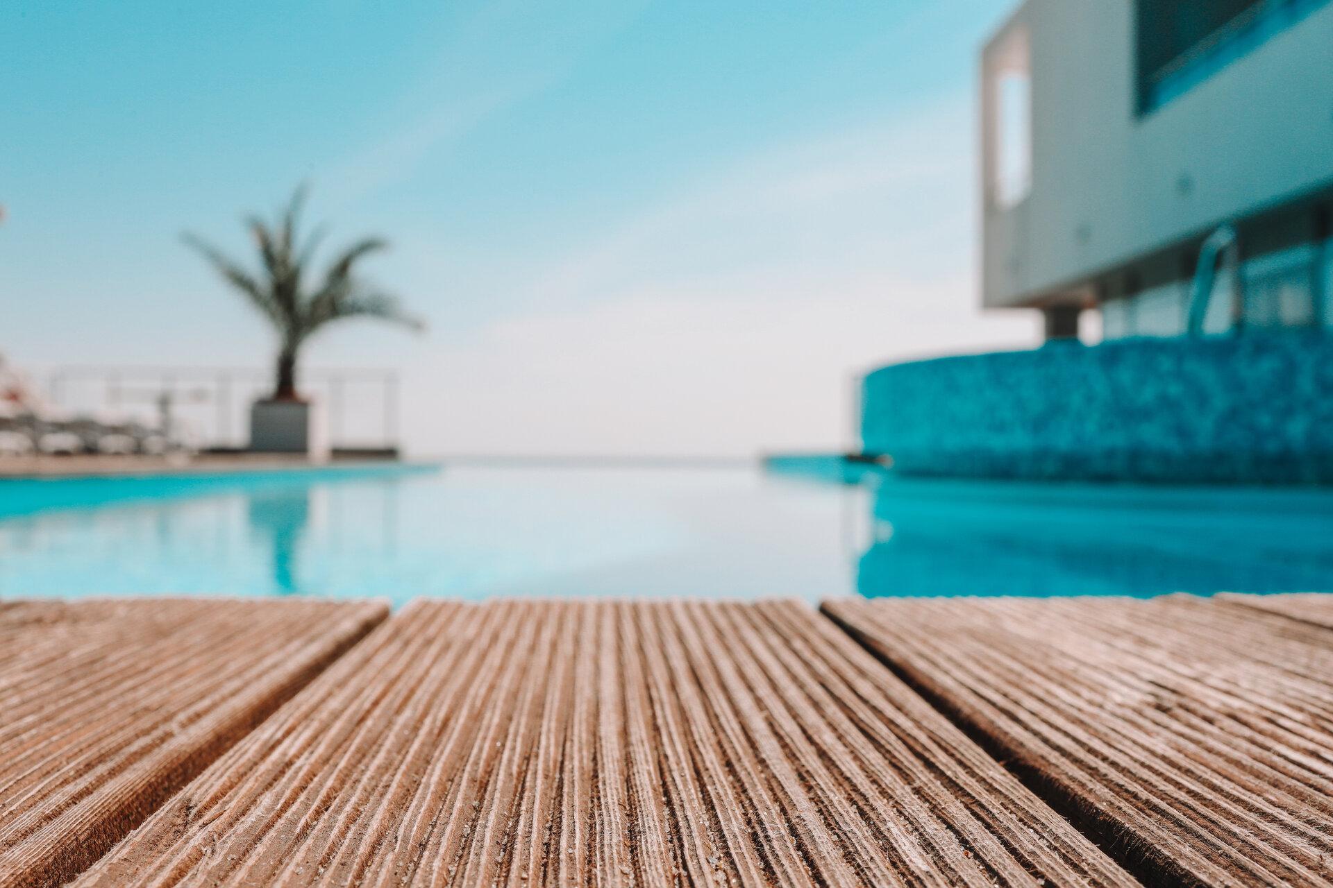 Leere Holzdeck mit Schwimmbad , Schöne minimalistische Pool Seite Blick mit klaren blauen Himmel . 